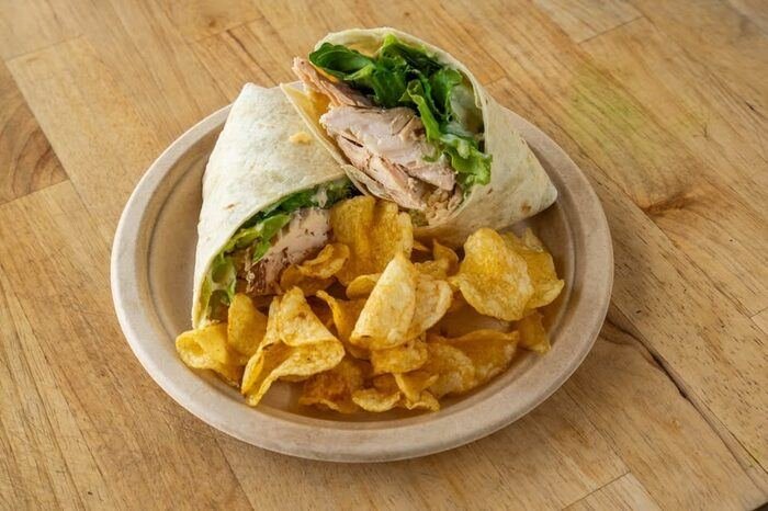 Chicken wrap with chips, wide shot
